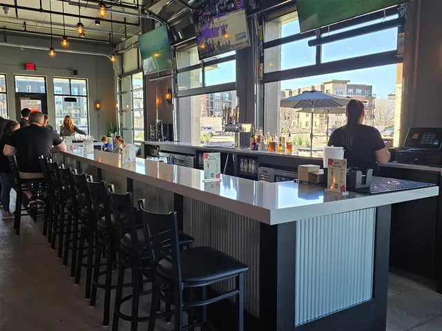 Modern bar area with craft cocktails and TVs at The Bogey Factory